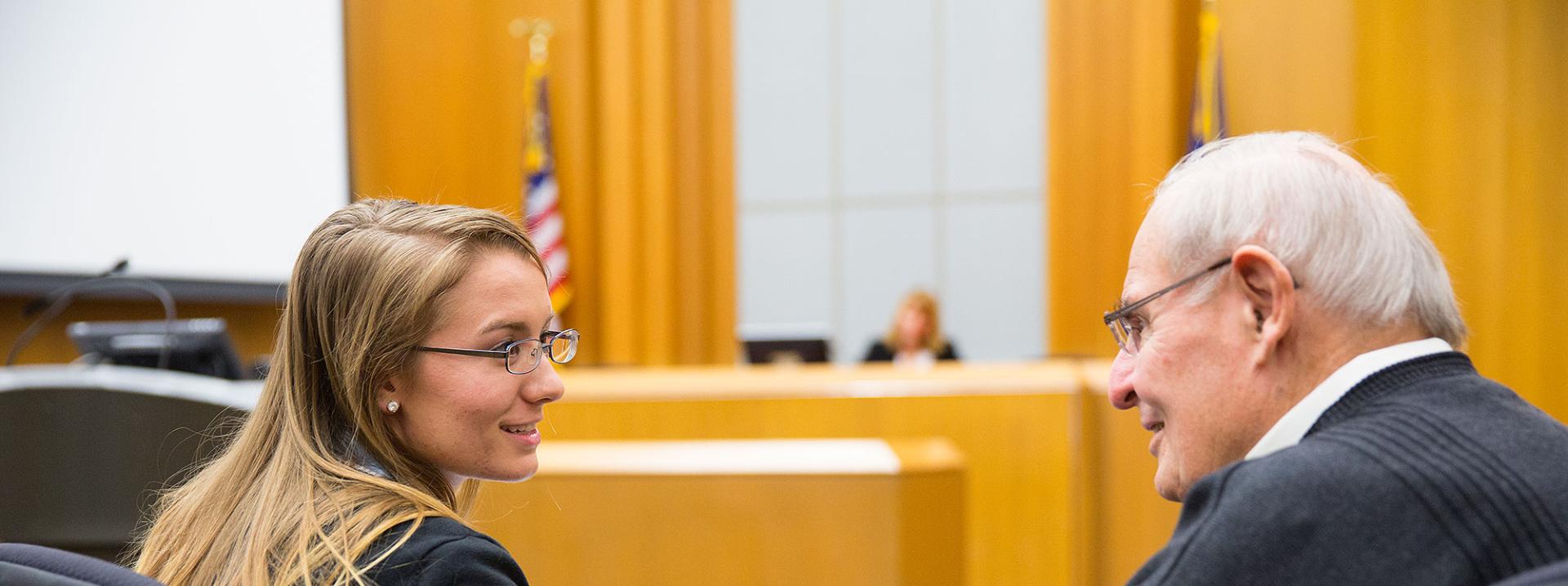 young woman old man discussing in front of woman judge