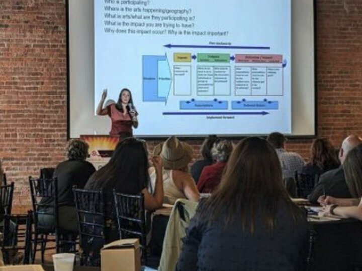 woman speaking in front of audience