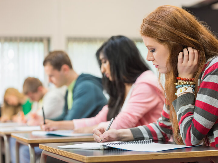 row of students taking notes in class